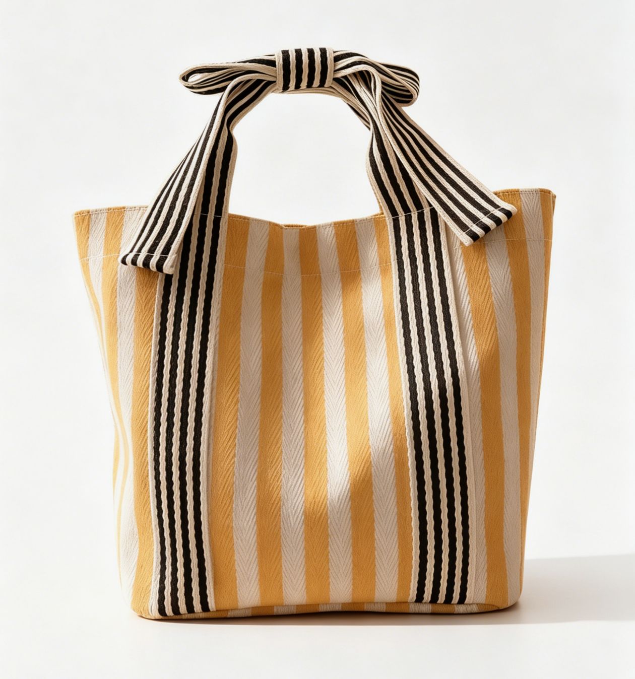 Striped tote bag with black and white handle on a white background